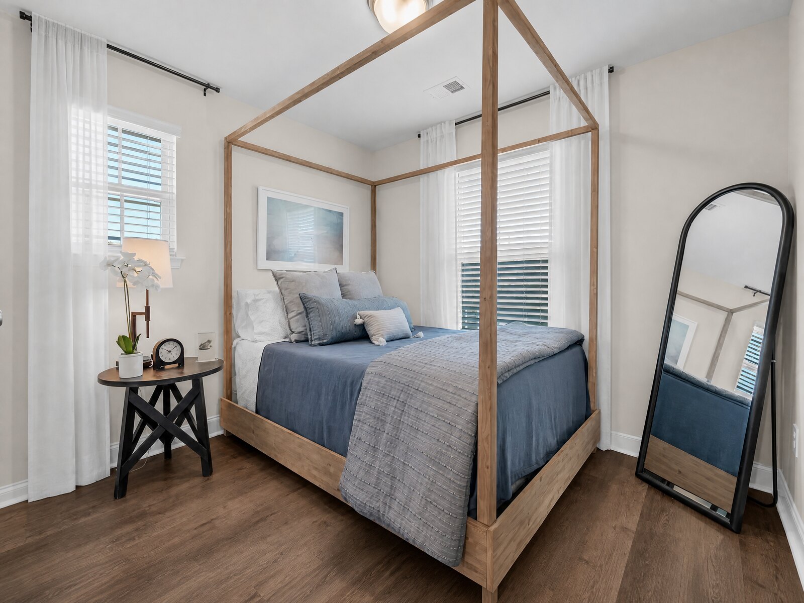 Serene bedroom with light wood canopy bed and blue bedding