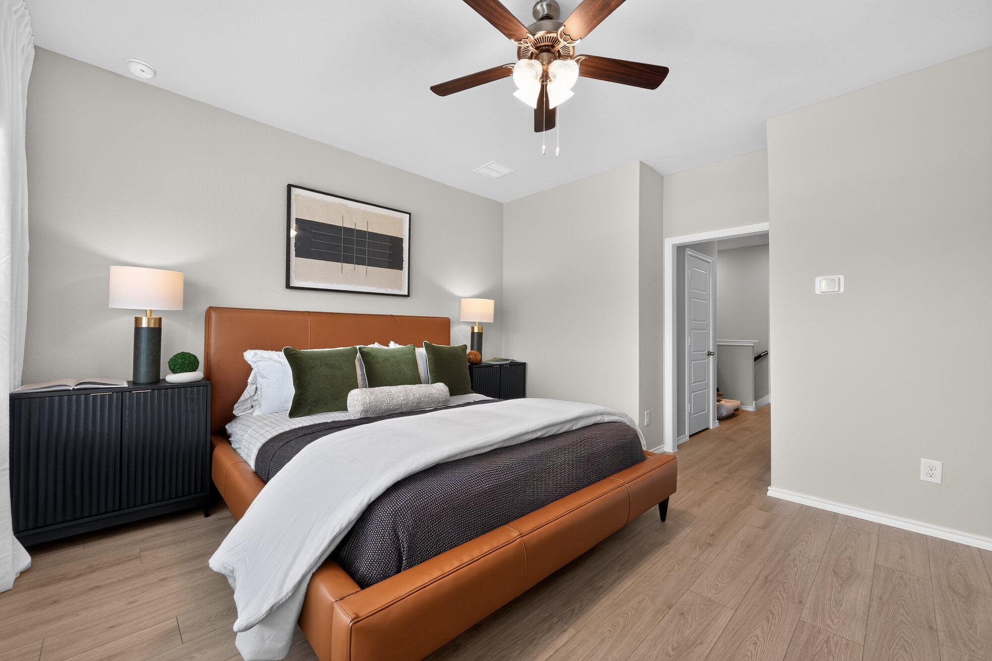 Modern bedroom with cognac leather bed and green accents