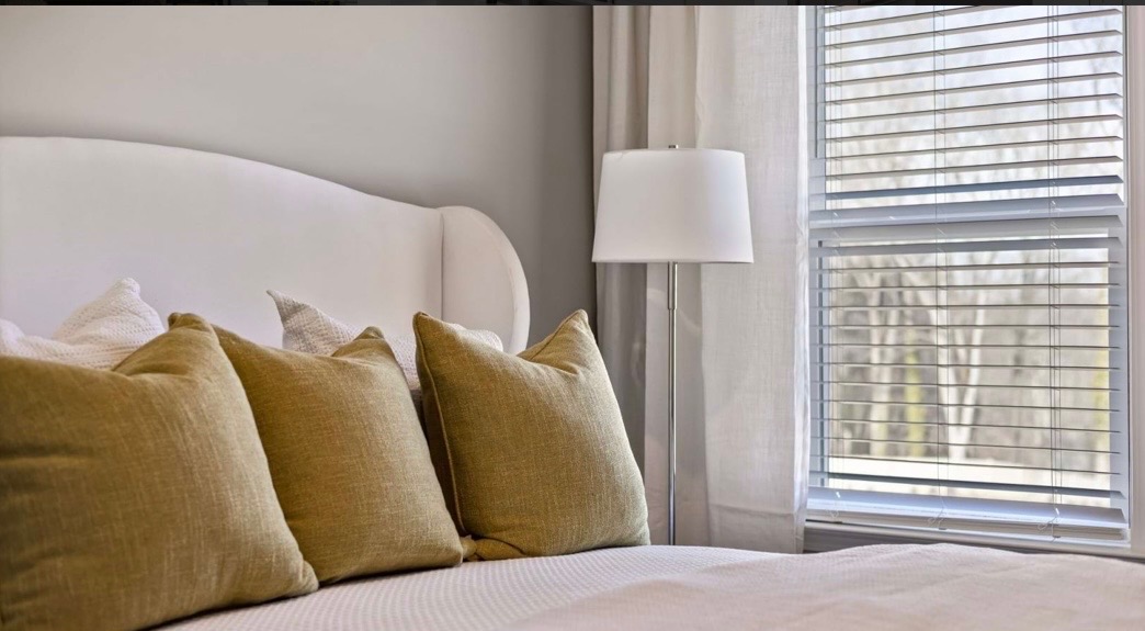 Bedroom detail with olive linen pillows and floor lamp