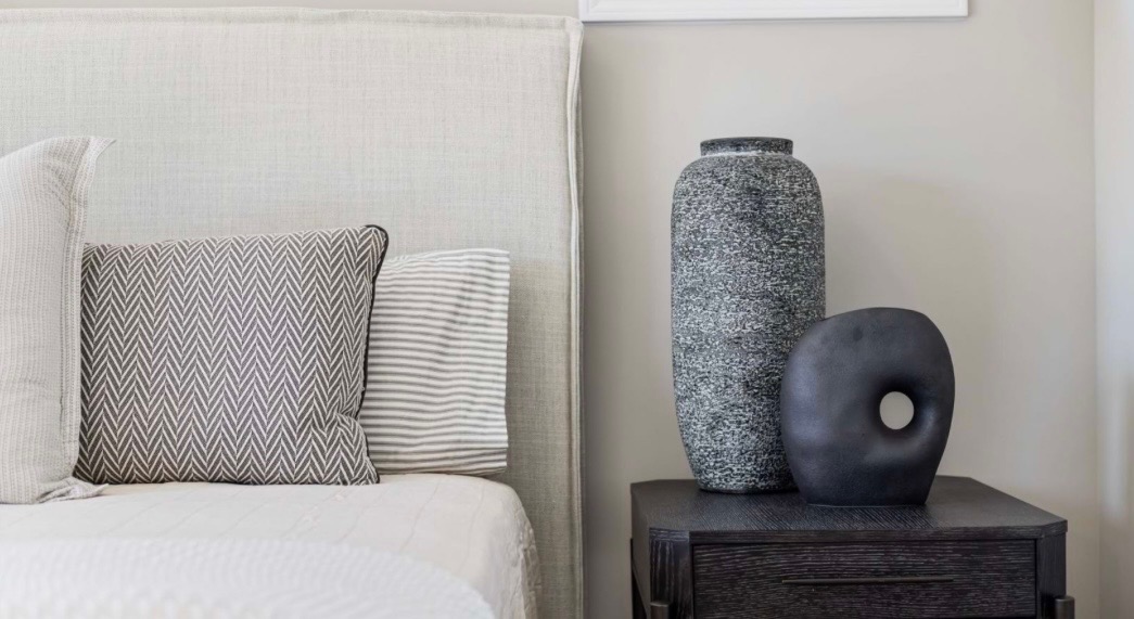 Nightstand styling with textured vases and herringbone pillows