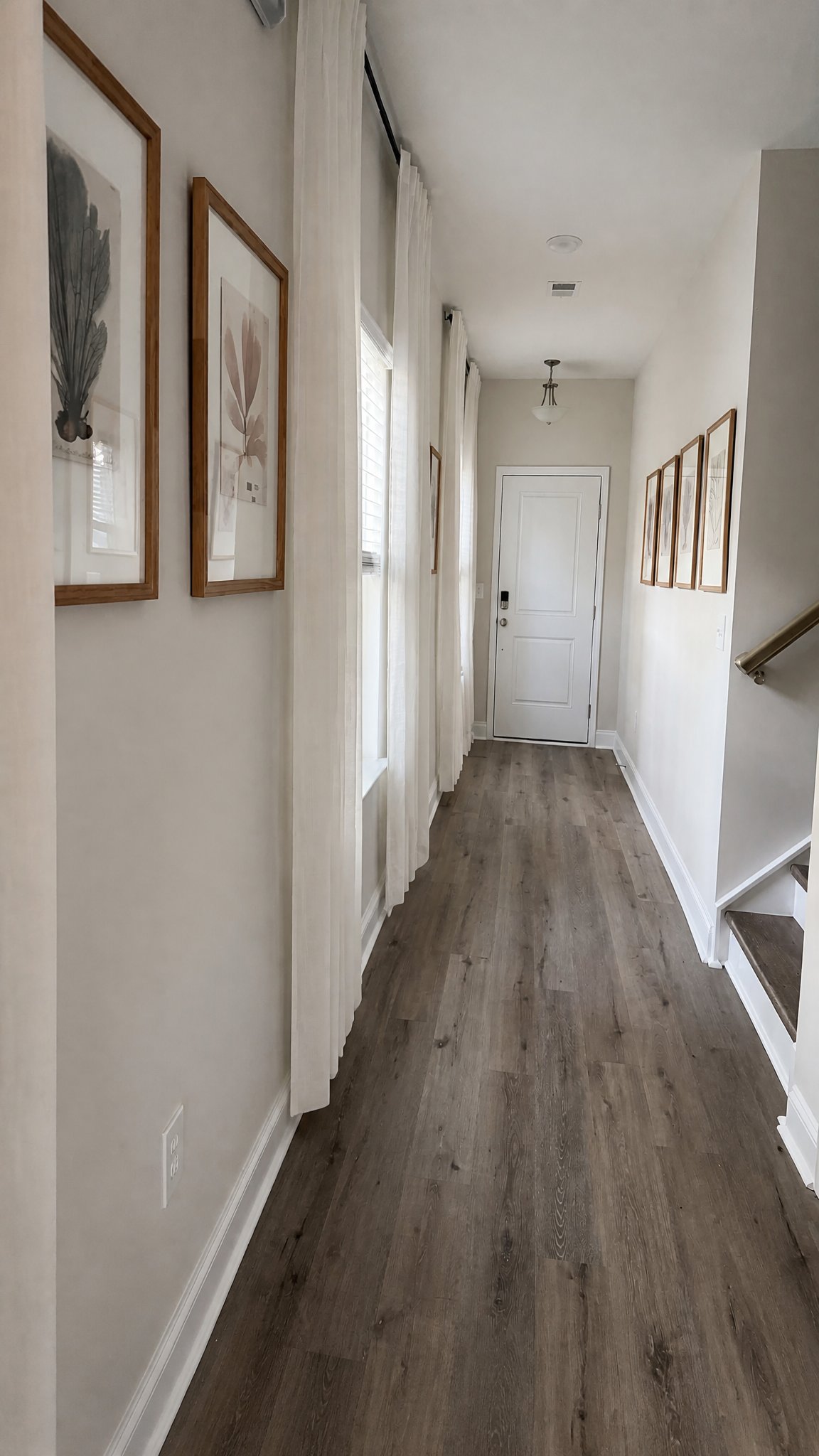 Elegant entryway hallway with botanical art gallery