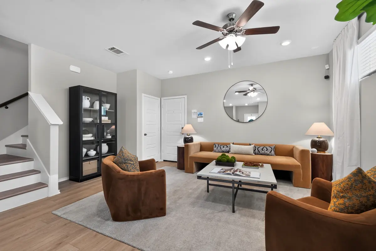 Warm living room with caramel sofa and round mirror